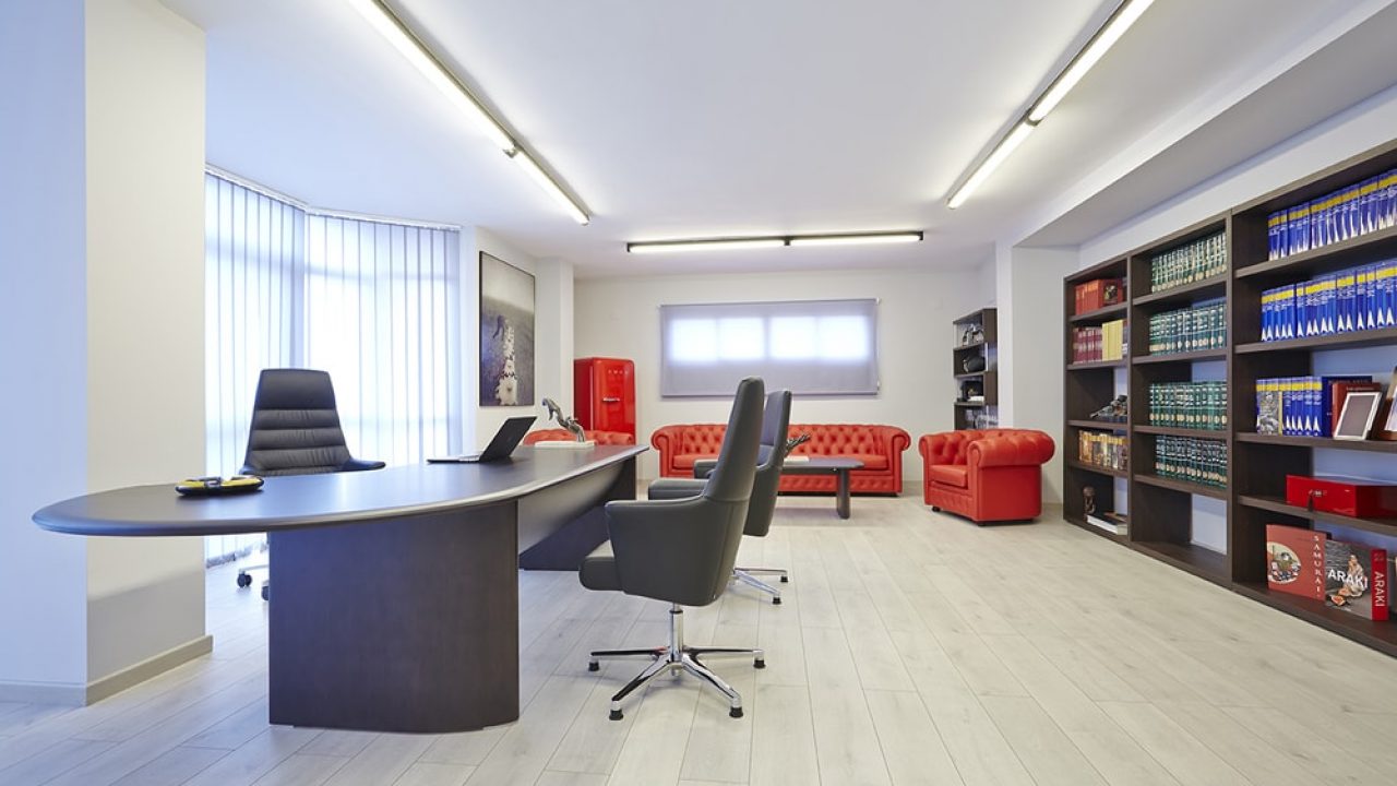 Oficina con muebles de madera y sofas rojos